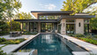 © RUK Collections - A sleek modern home with a smooth light gray exterior, black trim, and large glass doors opening to a landscaped backyard with a swimming pool.