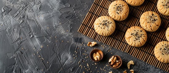 Top view of delicious walnut cookies on a sushi mat sprinkled with black sesame seeds, creating an appealing dessert display with space for text or images. Copy space image