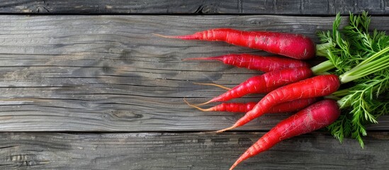 Poster - Top view of red carrots on an aged wooden surface with room for text or other elements in the image. Copy space image. Place for adding text and design