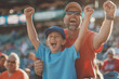© Татьяна Евдокимова - Father and son are cheering with their arms raised in the air while watching a baseball game