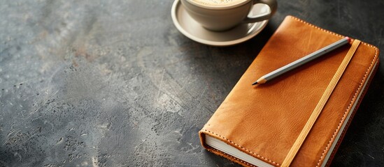 Fototapete - Craft notebook with a leather cover and a gray pencil displayed on a coffee background with ample copy space image.