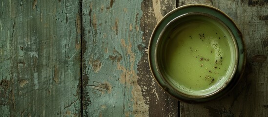 Poster - From above, a creamy broccoli soup in a green bowl sits on a rustic table, with a backdrop suitable for added elements in the frame, such as a copy space image.