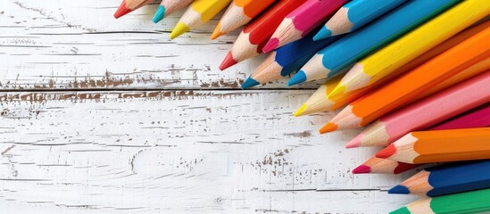Poster - Brightly colored pencils arranged on a white wooden backdrop provide a creative border with copy space image, embodying a school preparation theme for kids' gifts.