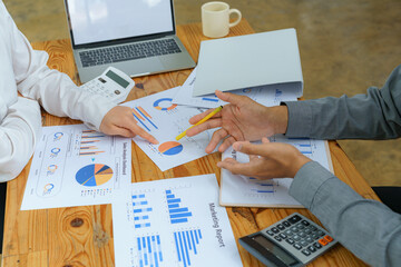 Wall Mural - Close-up of diverse businesspeople gathering at the office desk to discuss company financial paperwork at a meeting together, multiracial colleagues brainstorm work with documents at an office.