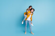 © deagreez - Full size photo of two nice young partners piggyback wear shirt isolated on blue color background