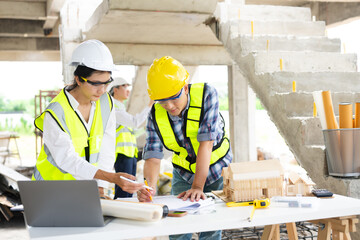 Wall Mural - Engineer teams meeting working together wear worker helmets hardhat on construction site in city.