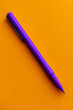© Nasreen - A purple pen positioned in the bottom left corner of a solid orange background, perfect for writing and drawing.