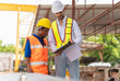 © Poguz.P - Engineer man and worker team inspect the construction site, Site manager and builder at a construction site.