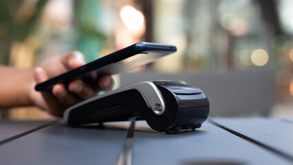 Man paying and purchasing with smartphone app and credit card information in a bar