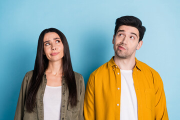 Poster - Photo of two nice young partners look empty space wear shirt isolated on blue color background