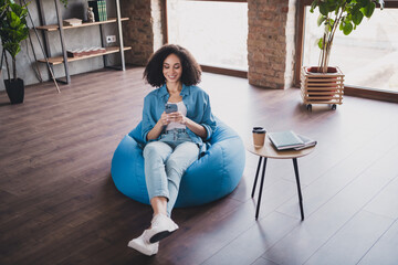 Sticker - Photo of charming lovely successful woman sitting pouf in cozy modern office room indoors