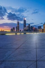 Wall Mural - Empty square floor with modern city buildings scenery at night in Guangzhou. car background.