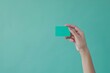 © Mark - Mockup of a female hand holding a levitating template for a bank credit card with online services isolated on an earthy background