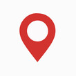 © Hogr - A red location pin icon, commonly used in maps and navigation applications. The pin is designed with a triangular shape pointing downwards, and it has a circular hole in the top center.