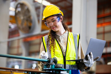 engineer female using laptop working in manufacturing factory. woman worker technician metalwork automated mechanical energy project.