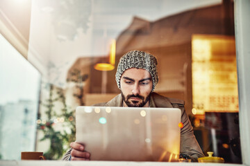 Poster - Man, reading and laptop in cafe by window with studying, internet search and digital elearning. Coffee shop, restaurant and computer with typing, email and online university website with student