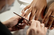 © Seventyfour - Close up shot of female manicurists hands working on Black womans nails using nail file to shape clients nails in natural style in beauty studio