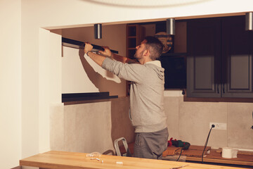 Wall Mural - Handyman assembling  kitchen cabinets and shelf.