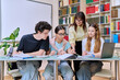 © Valerii Honcharuk - Group of teenage students with female teacher study inside classroom library