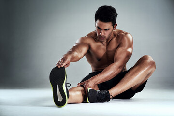 Poster - Man, stretching legs and fitness in studio on floor, health and circulation for performance by white background. Person, athlete and start warm up with exercise, training or workout for muscle growth