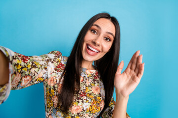 Wall Mural - Photo of cheerful pretty lady dressed print clothes recording video vlog waving arm hi empty space isolated blue color background