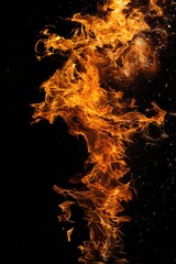 Poster - A fiery flame burning brightly on a dark and mysterious black background