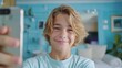 © Png - A smiling young person is taking a selfie in a blue room
