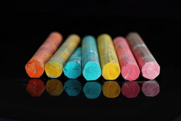 Poster - A collection of brightly colored chalk sticks arranged on a dark background