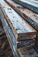 Wall Mural - A stack of steel beams rests on a mound of earth, waiting for construction to begin