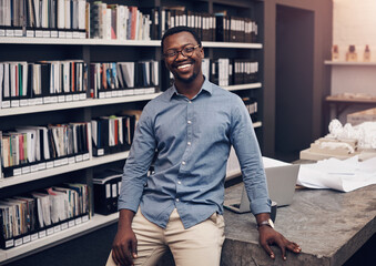 Poster - Black man, portrait smile and standing by desk with confidence for startup, construction business and laptop in office. African guy, happy and entrepreneur for architecture job, design and computer