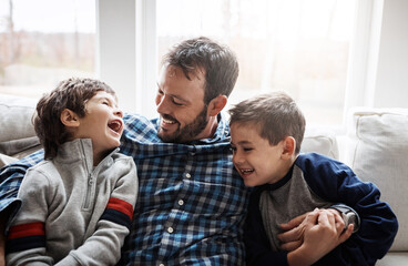 Wall Mural - Laugh, hug and father with children on sofa for bonding, loving relationship and relax together in home. Family, happy and dad with young boys embrace for affection, care and love in living room