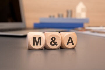 Poster - M and A acronym on marketing documents on dices. Mergers and Acquisitions concept