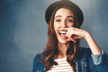 Canvas Print - Happy woman, finger and mustache in studio with portrait for quirky behavior, facial expression and funny face with hat. Silly, hand gesture and creative humor, goofy and playful on dark background.