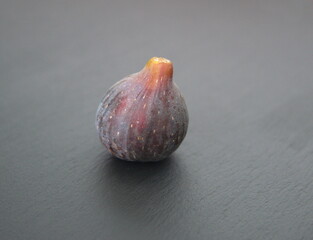 Fruits of Ficus carica, Asian species of flowering plant in the mulberry family, known as the common fig, on grey stone background 