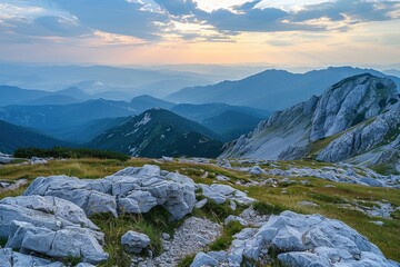Wall Mural - A mountain range with a beautiful sunset in the background. The sky is filled with clouds, and the mountains are covered in snow. The scene is serene and peaceful