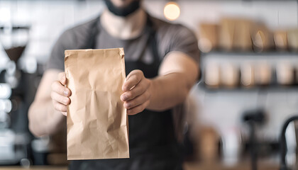 Wall Mural - Male barista showing takeaway coffee in the paper bag