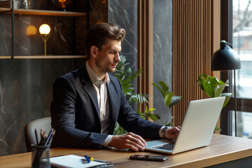 businessman in a well-fitted suit, sitting at a modern office desk, typing on a laptop. the setting 