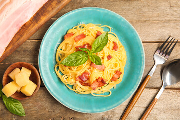 Wall Mural - Plate with tasty pasta carbonara on wooden background