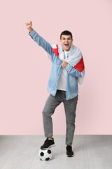 Wall Mural - Young man with soccer ball and flag of England near pink wall