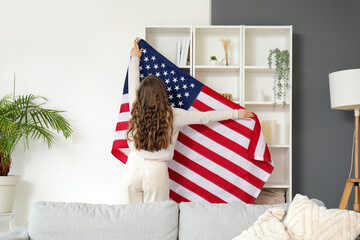 Sticker - Woman hanging USA flag on shelf unit in living room, back view