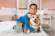 © Pixel-Shot - Little happy Asian boy with cute Corgi dog siting on bed at home