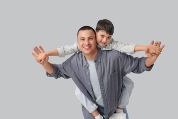 Poster - Cute little boy with his father on light background