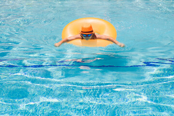 Wall Mural - Child splashing in swimming pool. Active healthy lifestyle, swim water sport activity on summer vacation with child. Child water toys.