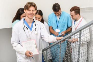 Canvas Print - Male doctor with clipboard on stairs in clinic