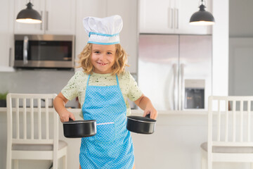 Wall Mural - Kid chef cook cookery at kitchen. Cooking, culinary and kids. Little boy in chefs hat and apron.