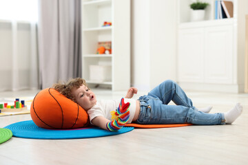 Sticker - Cute little boy playing with funny sock puppet on floor in kindergarten