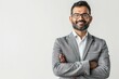 © Bijac - charismatic indian businessman in smart casual attire standing confidently with folded hands warm smile and professional demeanor against clean white background