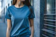© ylivdesign - Young woman is standing near a wall while wearing a blue t shirt