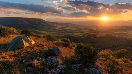 Wall Mural - A scenic campsite on a hilltop overlooking a sprawling valley bathed in the golden light of the setting sun.