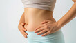 © ЮРИЙ ПОЗДНИКОВ - A woman gesturing towards her arm, waist, and chest muscles with hands on her stomach